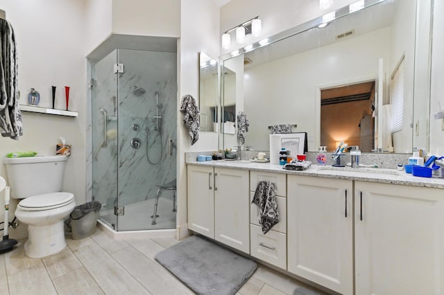 bathroom with vanity, toilet, and a shower with shower door