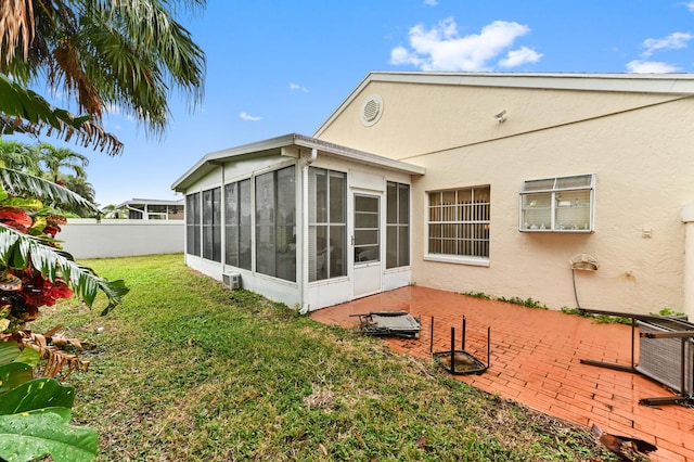 back of property featuring a yard, a patio area, and a sunroom