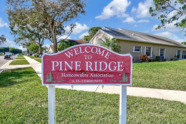 community sign featuring a lawn