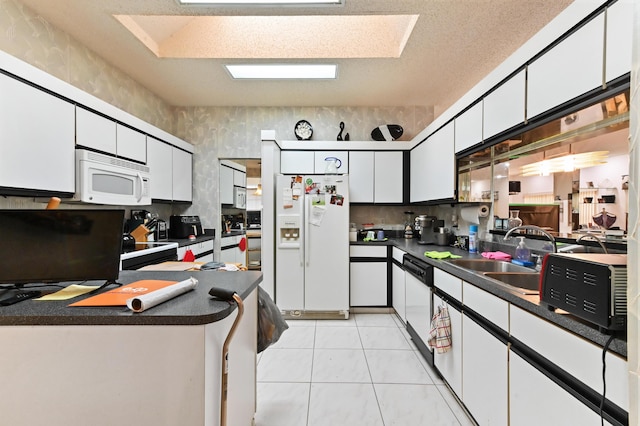 kitchen featuring white cabinets, white appliances, sink, and a textured ceiling