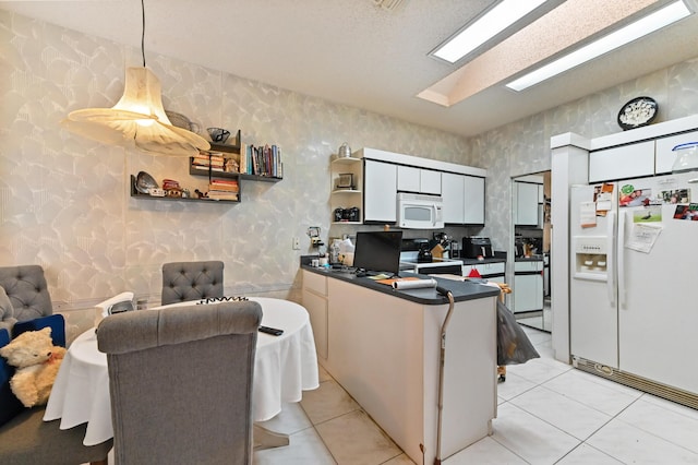 kitchen with white cabinets, white appliances, decorative light fixtures, and light tile patterned flooring