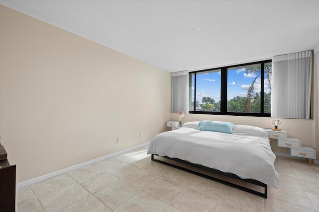 bedroom featuring a textured ceiling and light tile patterned flooring