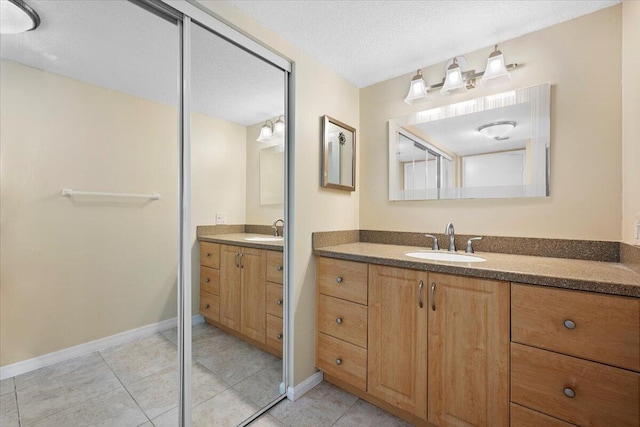 bathroom featuring vanity, tile patterned floors, and a textured ceiling