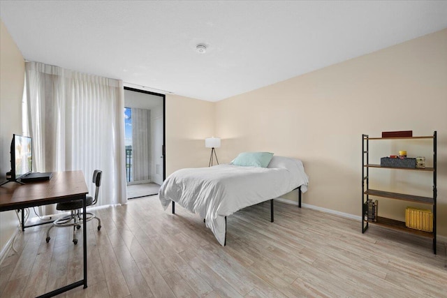 bedroom featuring access to exterior and light hardwood / wood-style flooring