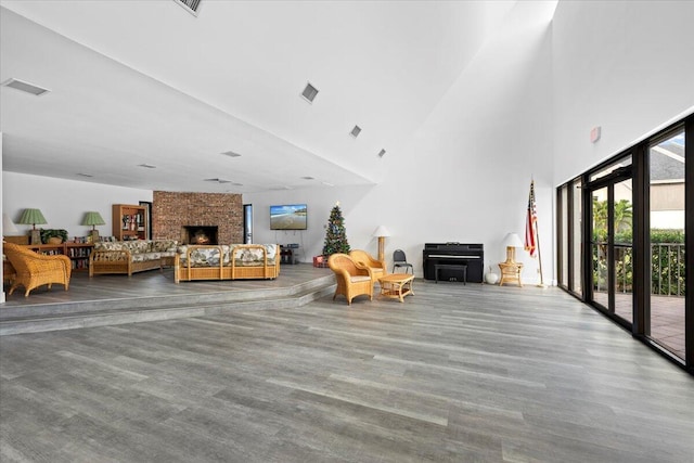 1605 S US Highway 1 Unit 203-M1, Jupiter, FL 33477 - living room with a large fireplace, a towering ceiling, and wood finished floors