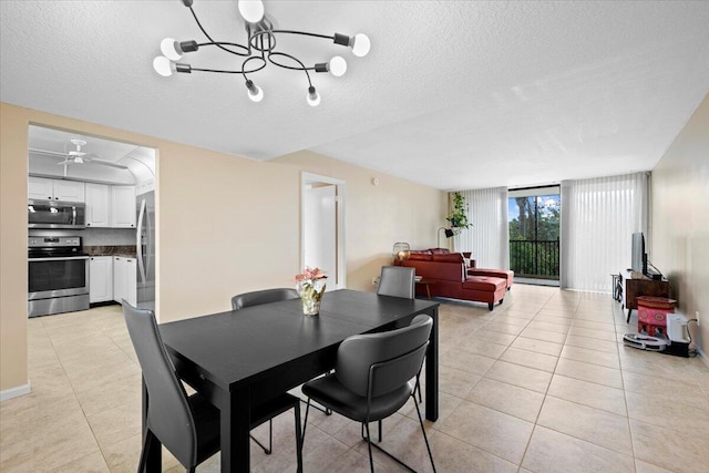 dining area with ceiling fan with notable chandelier, light tile patterned floors, and a textured ceiling