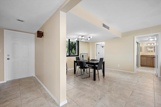 tiled dining space featuring a textured ceiling