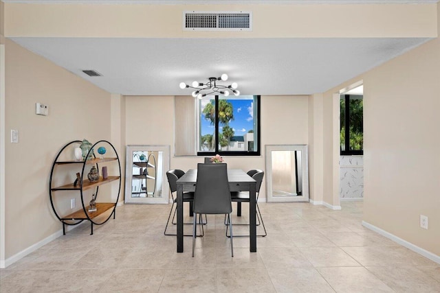 dining space featuring light tile patterned floors, baseboards, a chandelier, and visible vents
