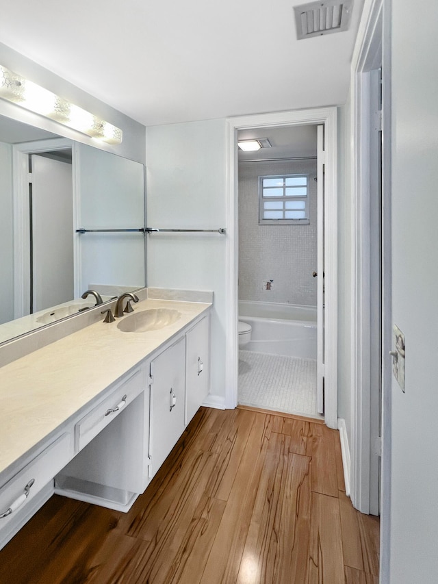 bathroom with hardwood / wood-style floors, vanity, and toilet