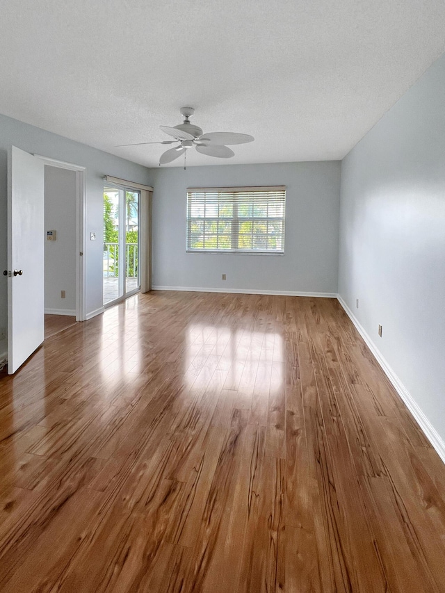 unfurnished room featuring hardwood / wood-style flooring, ceiling fan, and a textured ceiling