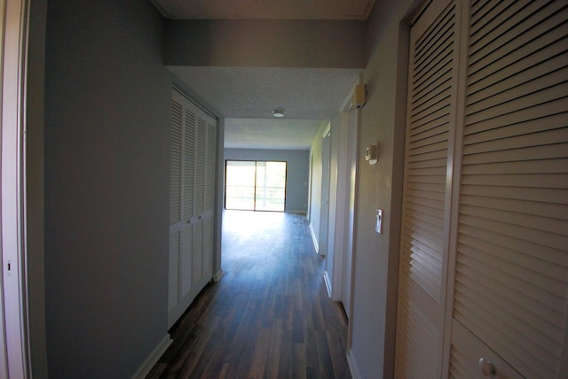 corridor with dark hardwood / wood-style flooring