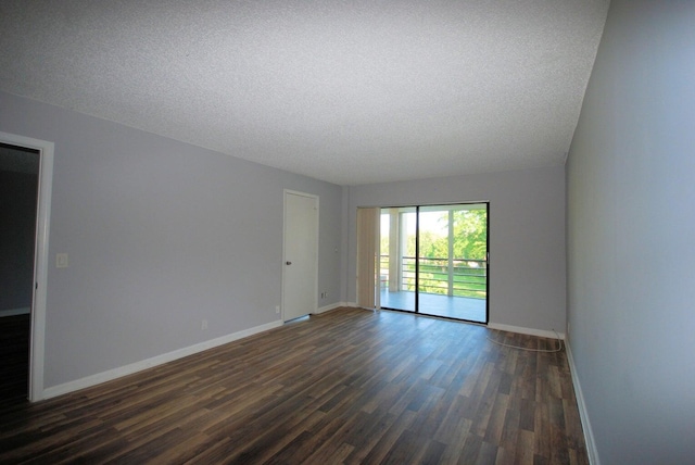 spare room featuring dark hardwood / wood-style flooring and a textured ceiling