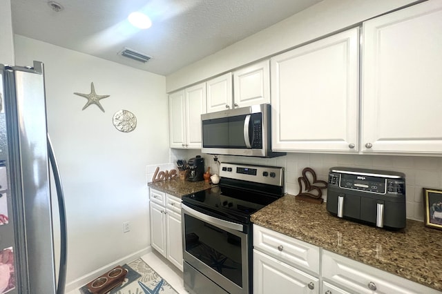 kitchen with stainless steel appliances, white cabinetry, and tasteful backsplash