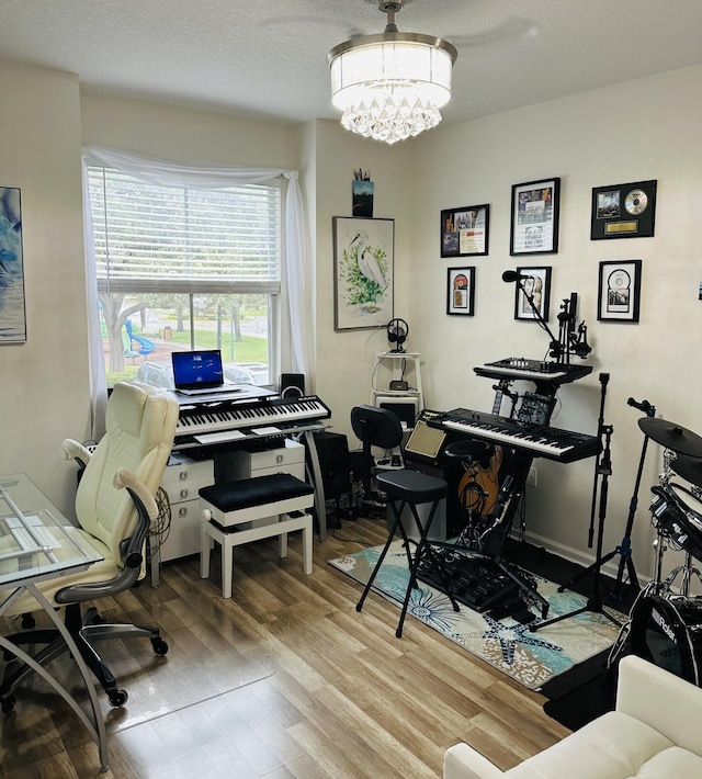 home office featuring wood-type flooring and a notable chandelier