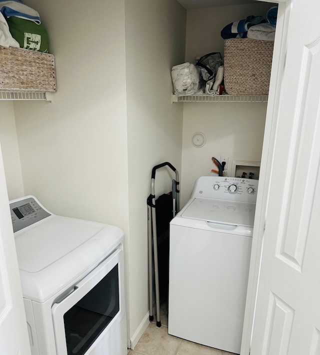 laundry area featuring washing machine and clothes dryer and light tile patterned floors