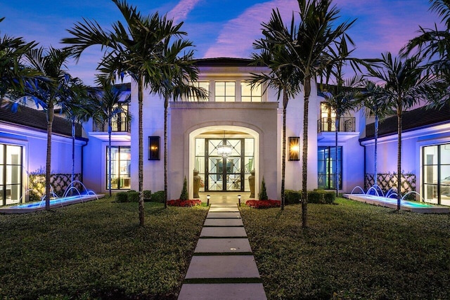 exterior entry at dusk featuring a yard