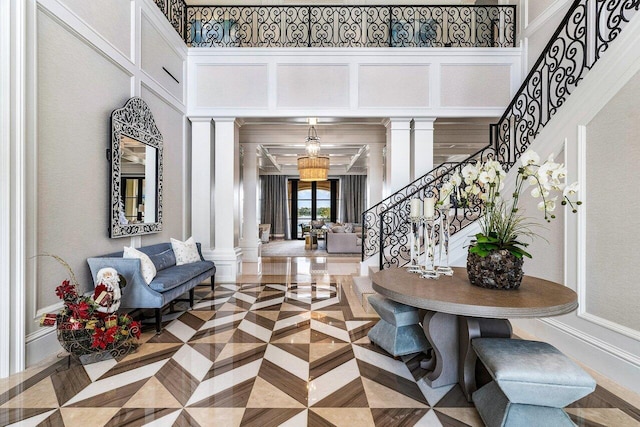 entryway with parquet flooring and ornate columns