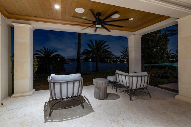 view of patio with ceiling fan and a water view