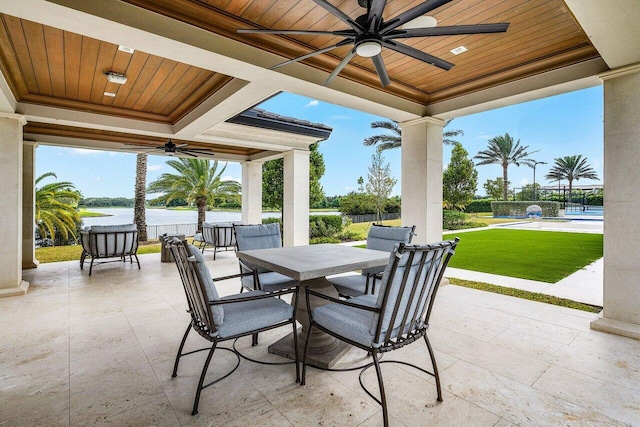 view of patio / terrace with a water view, ceiling fan, and a swimming pool