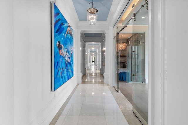 hall with crown molding, a chandelier, and tile patterned flooring