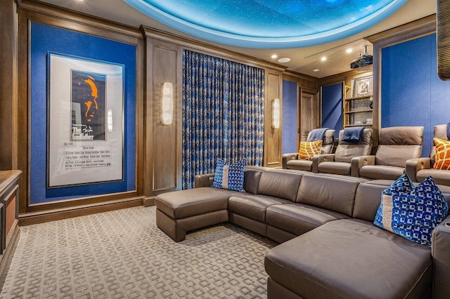 carpeted home theater with crown molding and a raised ceiling