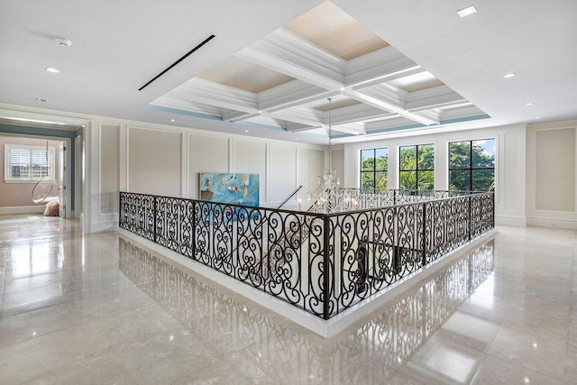 hallway featuring beam ceiling, crown molding, coffered ceiling, and a chandelier