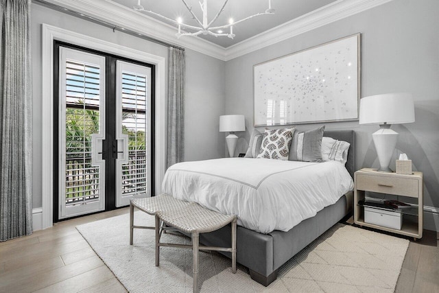 bedroom featuring a chandelier, ornamental molding, access to exterior, light wood-type flooring, and french doors