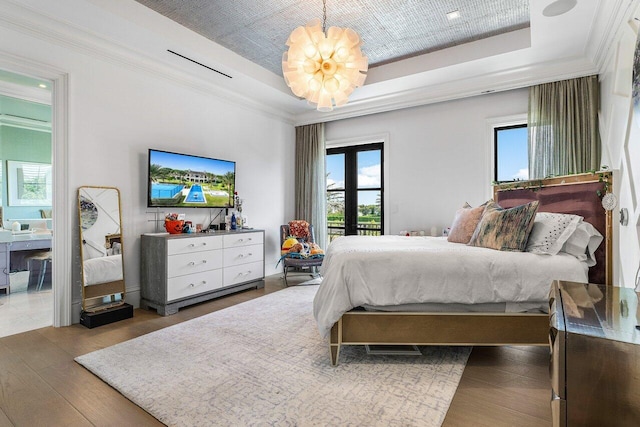 bedroom with crown molding, a raised ceiling, and access to outside