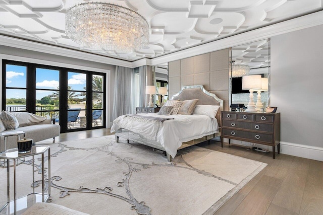 bedroom with a notable chandelier, hardwood / wood-style flooring, access to outside, and ornamental molding