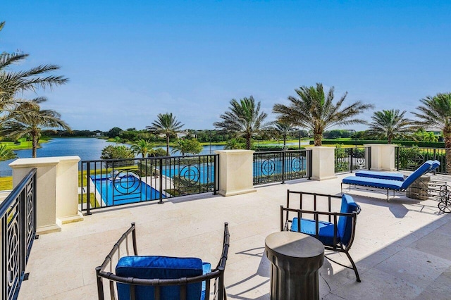 view of patio / terrace featuring a water view and a fenced in pool