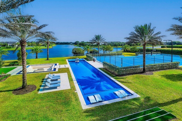 view of pool featuring tennis court, a lawn, and a water view