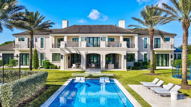 16071 Quiet Vista Cir, Delray Beach, FL 33446 - rear view of house with a patio area, stucco siding, a lawn, and a chimney