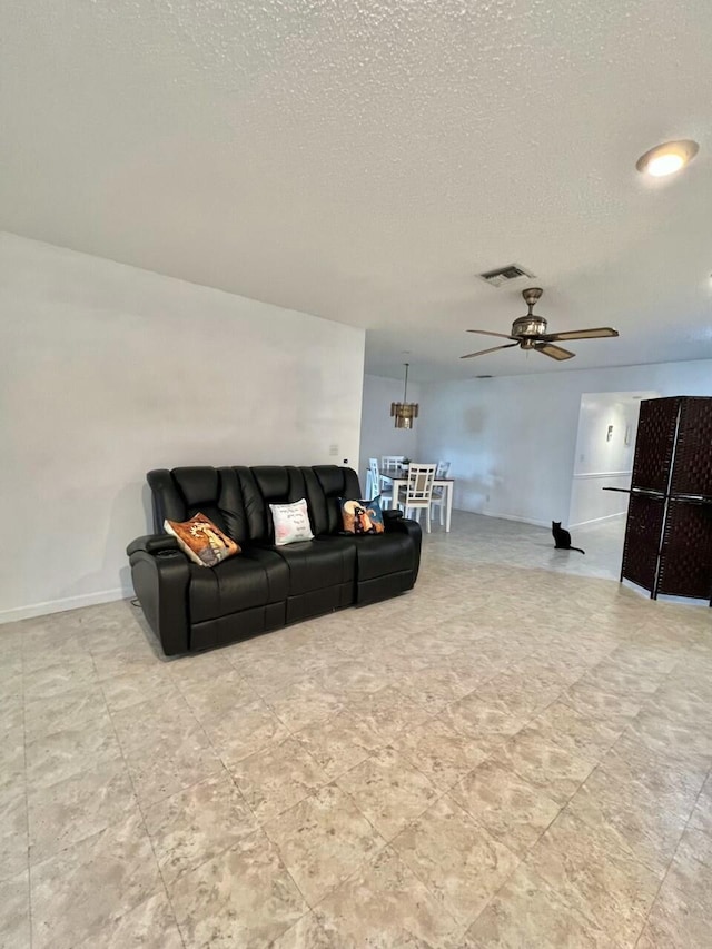 living room with a textured ceiling and ceiling fan