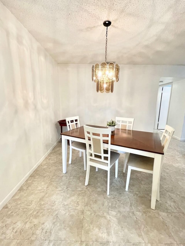 dining space featuring a chandelier and a textured ceiling