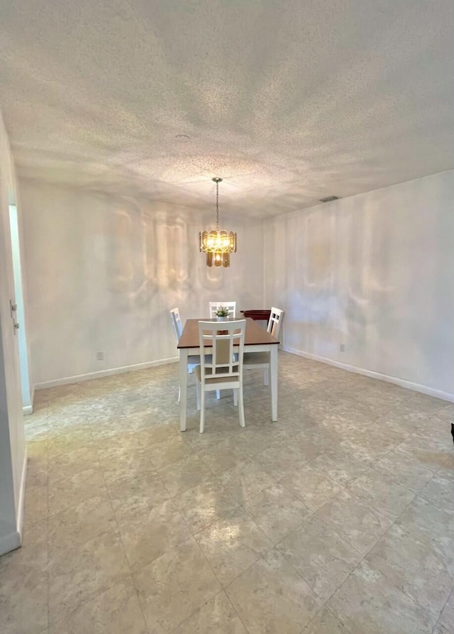 unfurnished dining area with a textured ceiling and an inviting chandelier