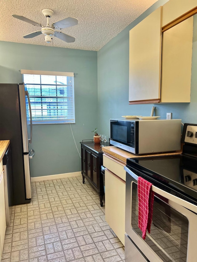 kitchen featuring ceiling fan, a textured ceiling, and appliances with stainless steel finishes