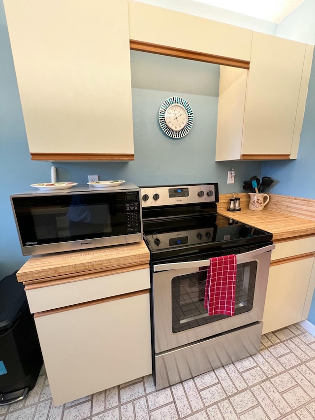 kitchen with cream cabinets and appliances with stainless steel finishes