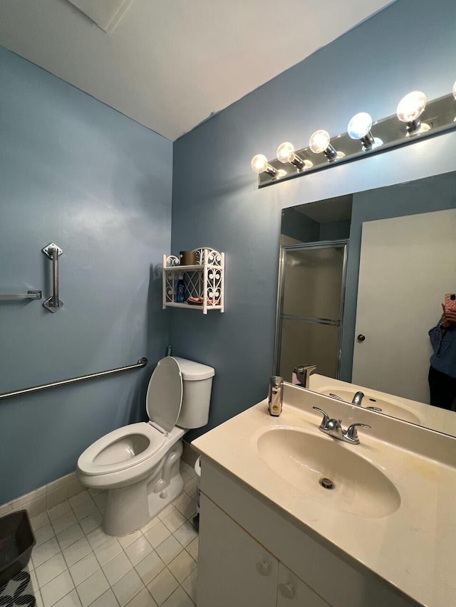 bathroom featuring tile patterned flooring, vanity, toilet, and an enclosed shower