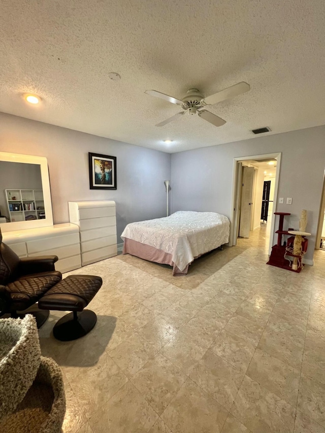 bedroom with ceiling fan and a textured ceiling