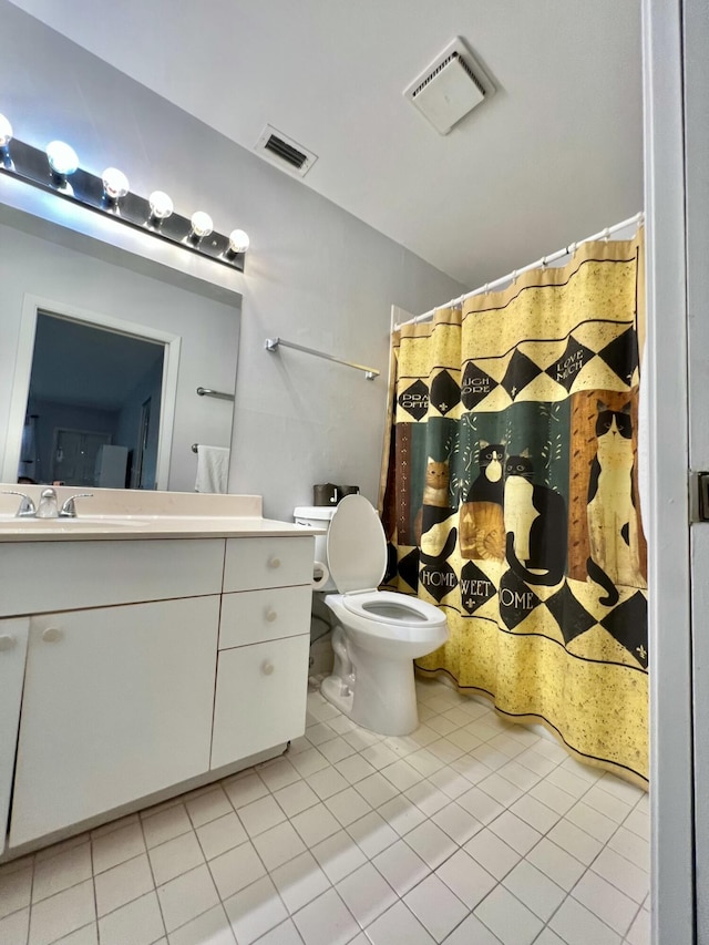 bathroom with tile patterned flooring, vanity, and toilet