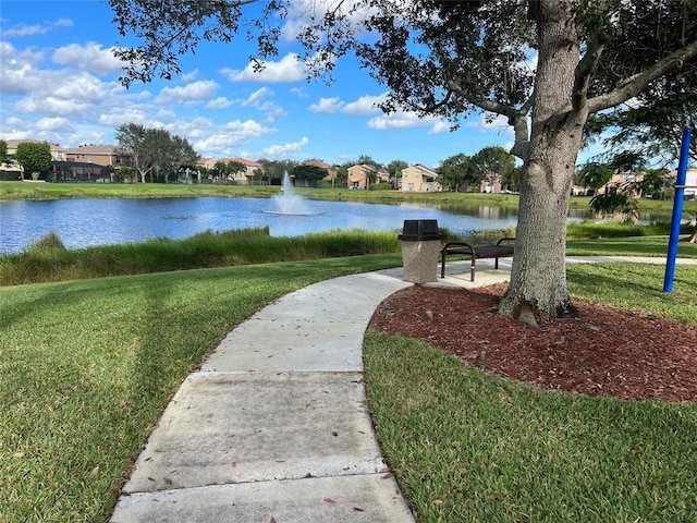 view of property's community with a water view and a yard