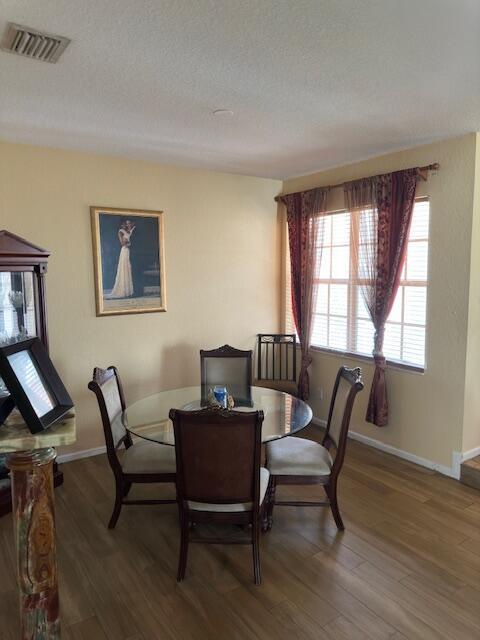 dining room featuring dark hardwood / wood-style floors and a textured ceiling