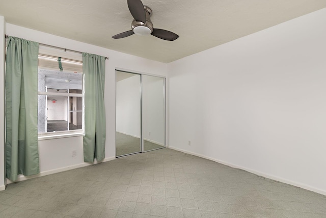 unfurnished bedroom featuring ceiling fan and a closet