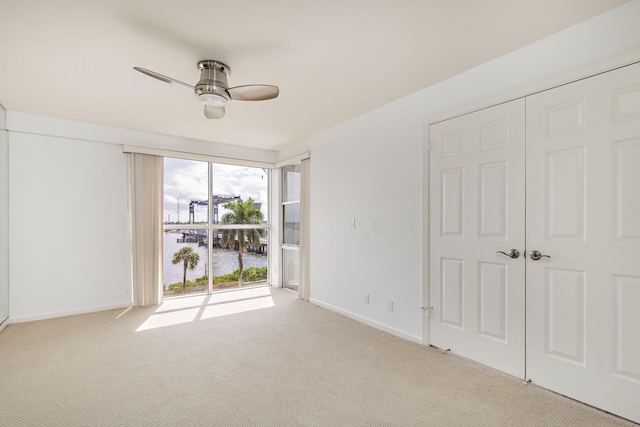 carpeted empty room featuring ceiling fan