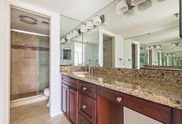 bathroom with tile patterned flooring, vanity, toilet, and a shower with shower door