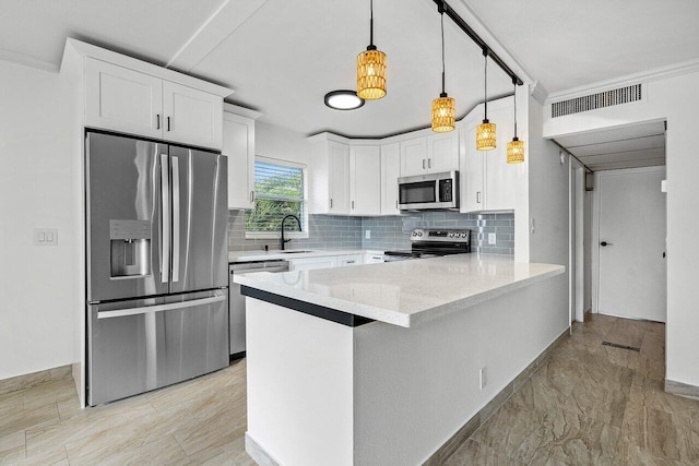 kitchen featuring white cabinets, appliances with stainless steel finishes, decorative light fixtures, and light stone countertops