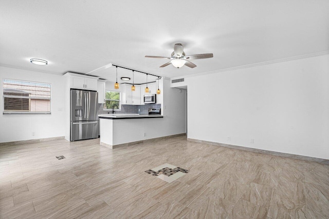 unfurnished living room with ceiling fan, ornamental molding, and sink