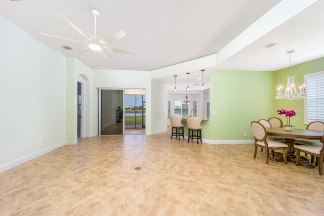 living room with a healthy amount of sunlight and ceiling fan with notable chandelier