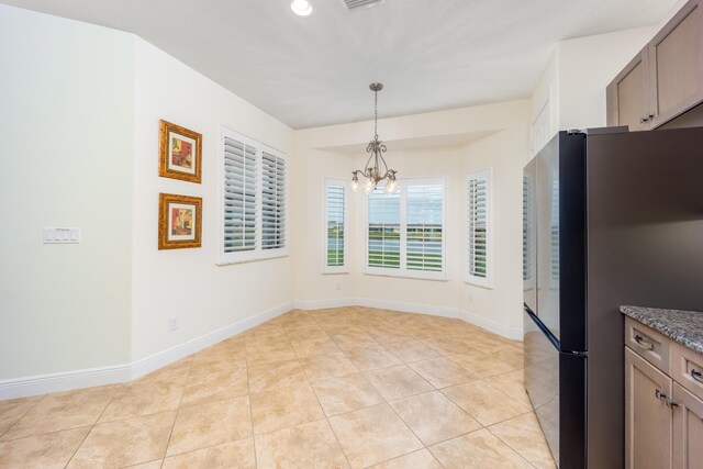 interior space with light tile patterned floors and an inviting chandelier