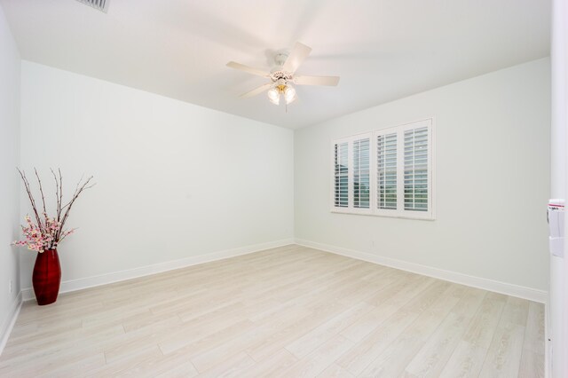 empty room with ceiling fan and light hardwood / wood-style flooring